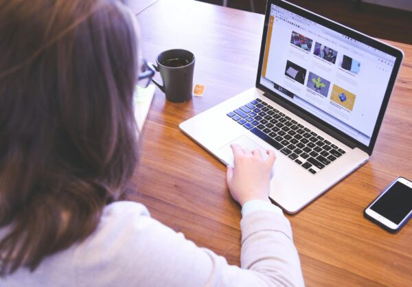 Person working on laptop building a real estate course creation funnel with webinar marketing and sales pages for lead generation.