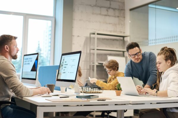 Marketing team collaborating on real estate course marketing strategy and webinar funnel setup in modern office workspace.