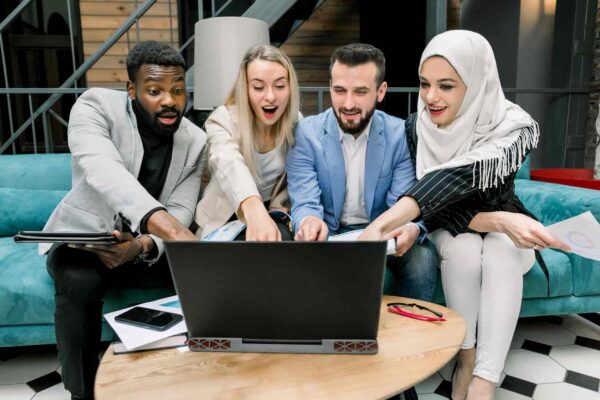 Team reviewing laptop analytics while building a real estate webinar marketing funnel for course creation and lead generation.